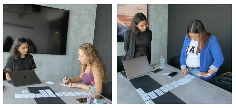 Participants arranging cards on a table during an in-person card sorting session